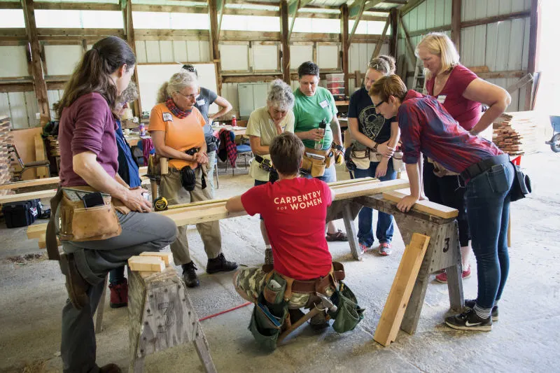 Photo by Robyn Wishna -- click to learn more about Hammerstone School’s two-day Basic Carpentry Skills A group of women gather around an instructor teaching carpentry skills.